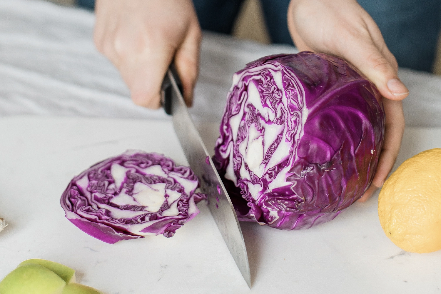 purple cabbaged being sliced on a chopping board